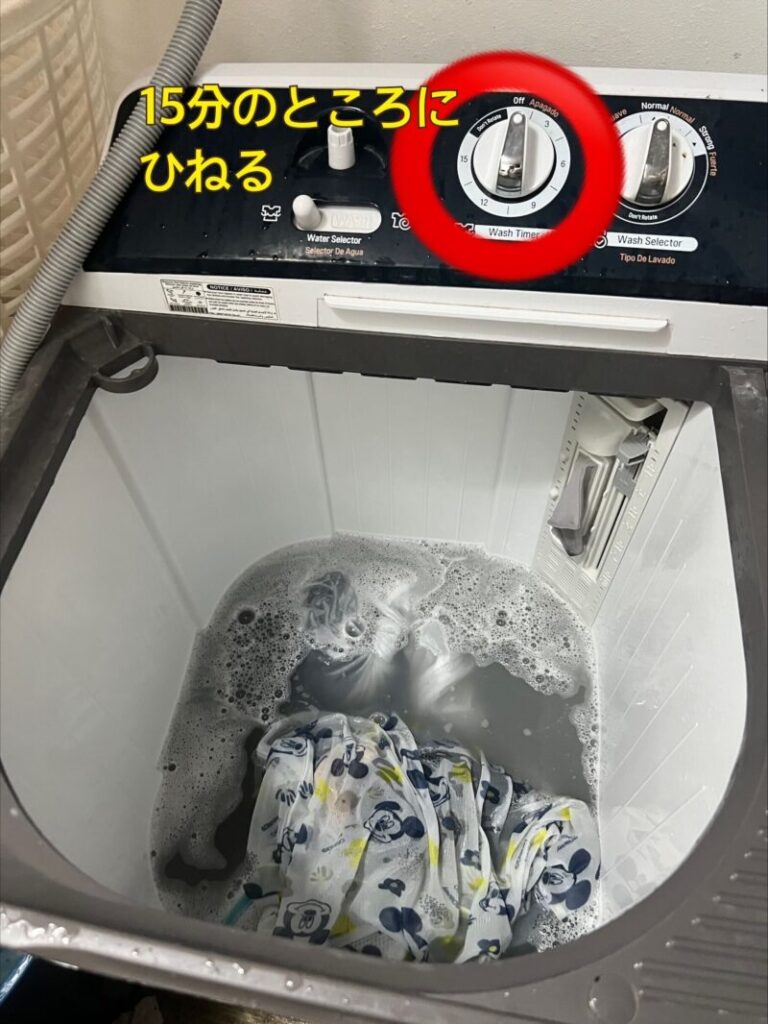 ドミニカ共和国の洗濯機の洗濯槽の写真です。洗濯物と洗剤が入っています。